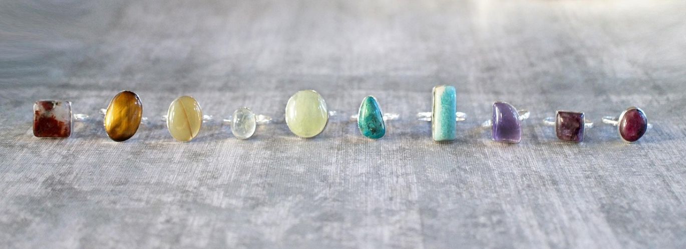 A collection of assorted cabochon charms for wholesale purchase, showcasing diverse gemstone types and colors.
