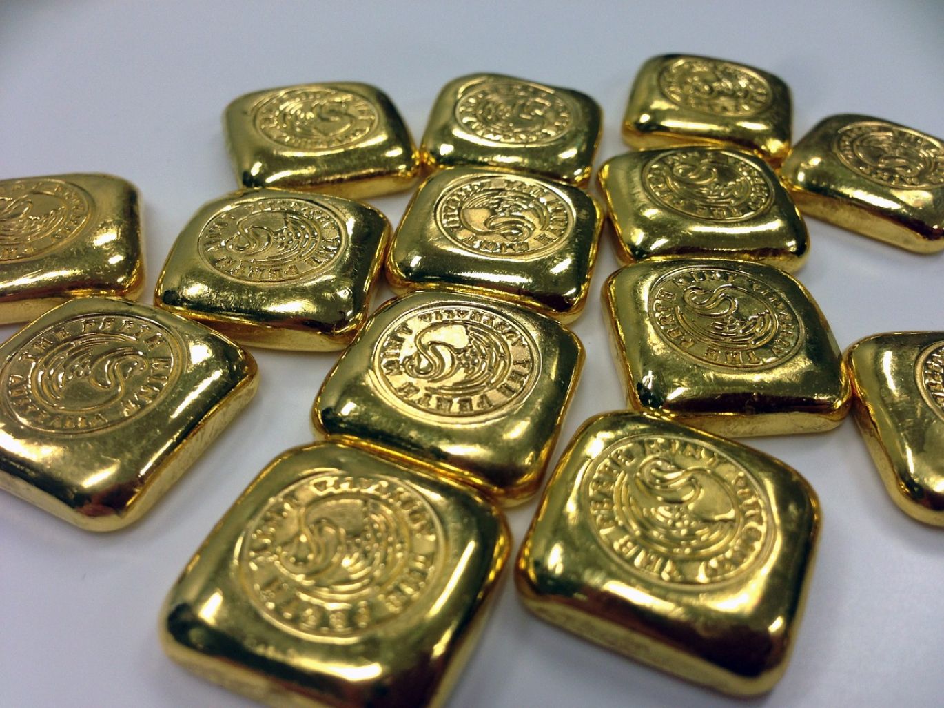 Close-up of certified gold bullion bars and coins, symbolizing Investing In Gold Bullion.