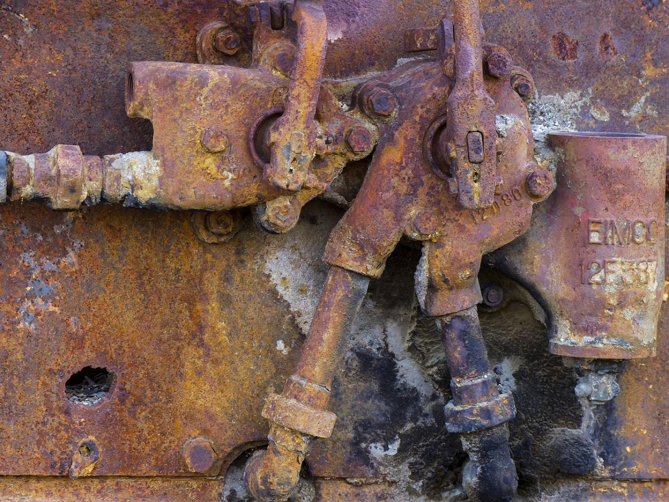 Close-up of various metallic ore minerals with a subtle background of a Kenyan mining operation.