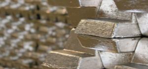 Close-up of gleaming silver bars stacked in a secure vault, with a subtle overlay of market charts indicating price fluctuations, set against a backdrop suggesting the vibrant industrial landscape of Coimbatore, India.