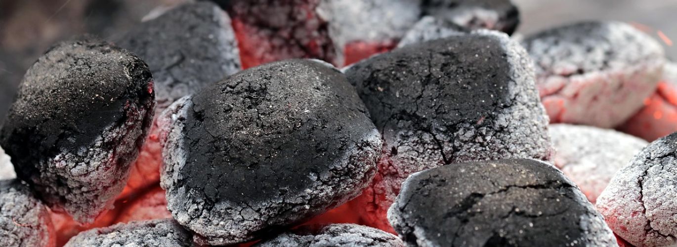 Close-up of white granular Sodium Carbonate Ash in an industrial setting, representing its use in manufacturing.